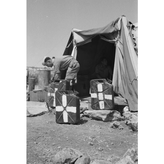 Des jerrycans devant une tente abritant un hôpital de campagne.