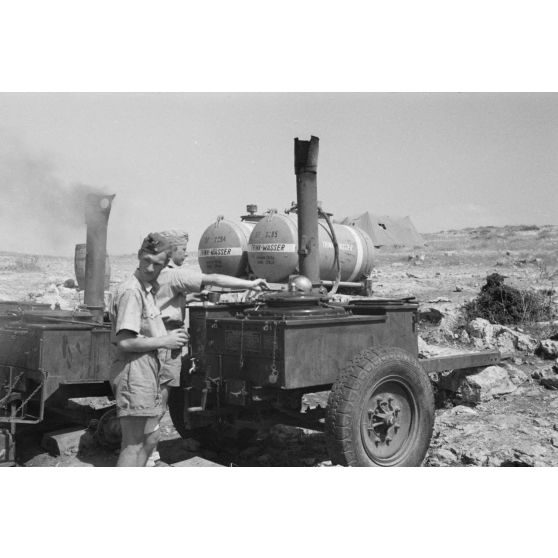 Des cuisines roulantes allemandes à proximité de citernes d'eau.