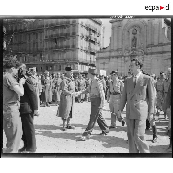 Le général de Lattre de Tassigny félicite un officier lors d'une cérémonie après la libération de Marseille.