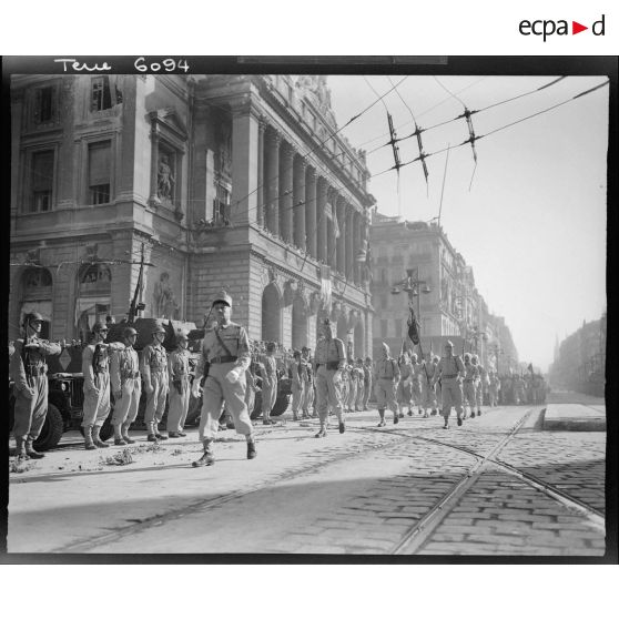 Défilé des troupes à pied sur la Canebière à l'issue de la cérémonie célébrant la libération de Marseille : le chef de corps, l'état-major et le drapeau d'une unité de tirailleurs.