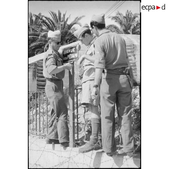 Des soldats français déboulonnent une plaque de rue au nom du maréchal Pétain à Sainte-Maxime.