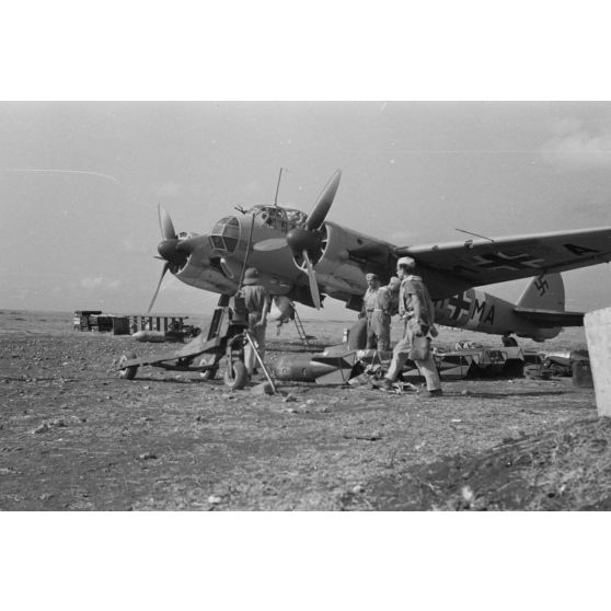 Sur une base aérienne de Cyrénaïque, un équipage de bombardier Junkers Ju-88 se prépare pour une mission.