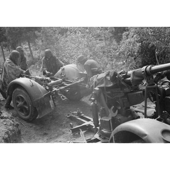 Démontage et attelage d'une pièce de DCA de 3,7 cm FlaK 18 : les servants tirent la pièce pour la relier à sa remorque.