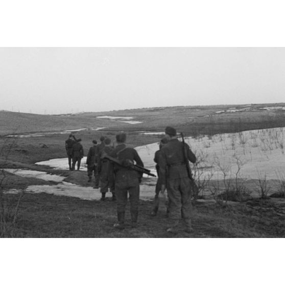 Une patrouille allemande marque une pause, de dos un fantassin est doté d'une mitrailleuse MG-42.