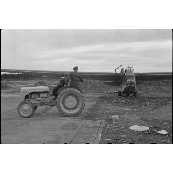 Sur la piste du terrain d'aviation, un tracteur agricole tracte le planeur DFS-230 du Luftlandegeschwader 1 (8./LLG 1) vers un nouvel emplacement.