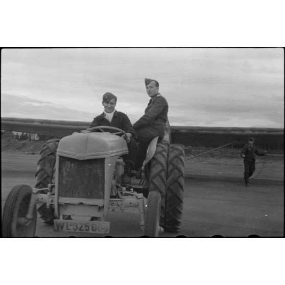 Sur la piste du terrain d'aviation, un tracteur agricole tracte le planeur DFS-230 du Luftlandegeschwader 1 (8./LLG 1) vers un nouvel emplacement.