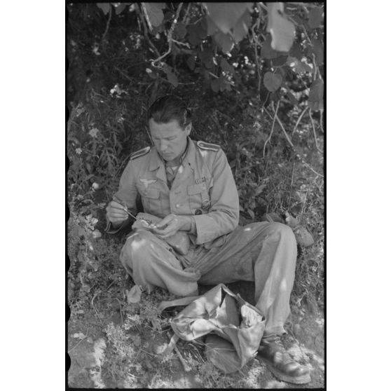 En Italie, sur le front d'Anzio-Nettuno (Latium), la pause déjeuner d'un reporter de la section de propagande aéroportée dans les lignes allemandes de la 4e division aéroportée allemande (4.Fallschirmjäger-Division).