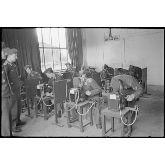 Dans une salle près d'un terrain d'aviation occupé par le II./LG1 (Lehrgeschwader 1), une formation sur les organes de visée de bombardiers est prodiguée.