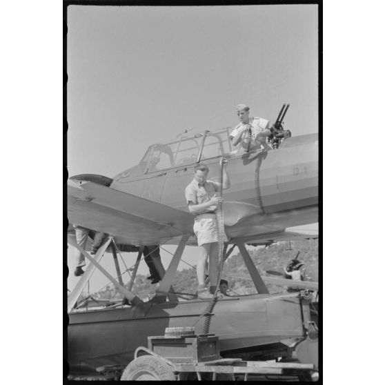 Sur la base de Skaramangas, deux mécaniciens de bord du Seeaufklärungsgruppe 126 approvisionnent les mitrailleuses MG-81 d'un hydravion Arado Ar-196 codé D1+BK.