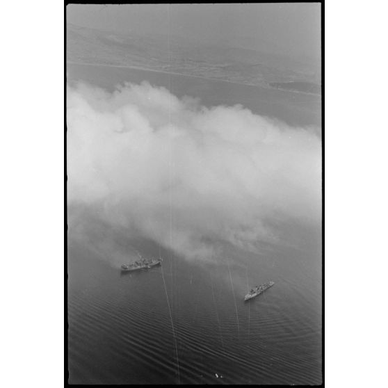 Dans le golfe d’Elefsina, l’équipage d’un hydravion Arado Ar-196 du Seeaufklärungsgruppe 126 basé à Skaramangas, assiste à un exercice de camouflage de la baie par la Kriegsmarine.