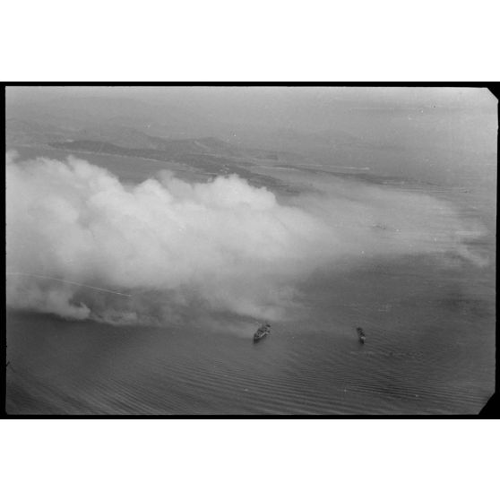 Dans le golfe d’Elefsina, l’équipage d’un hydravion Arado Ar-196 du Seeaufklärungsgruppe 126 basé à Skaramangas, assiste à un exercice de camouflage de la baie par la Kriegsmarine.