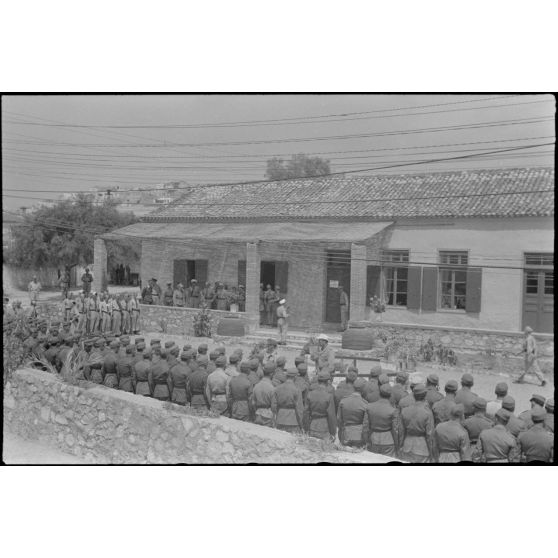 Devant le foyer du soldat (Soldatenheim) de Skaramangas, un général de l'armée de terre allemande commande une prise d'armes.