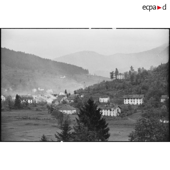 Vue du village de Cornimont cerné par les fumées des tirs d'artillerie.