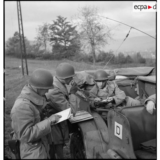 De son poste de commandement installé dans une voiture blindée, un colonel du 2e RD suit la progression des chars sur la carte et transmet ses ordres par radio.