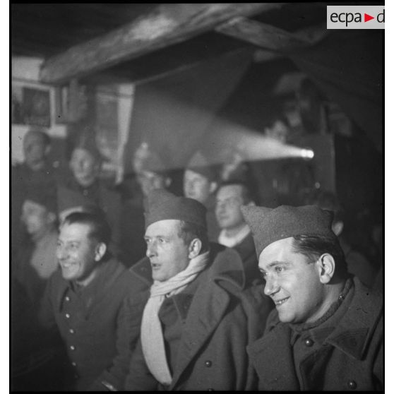 Photographie de groupe de soldats de différentes unités de la 2e armée qui assistent à une séance de cinéma aux armées.