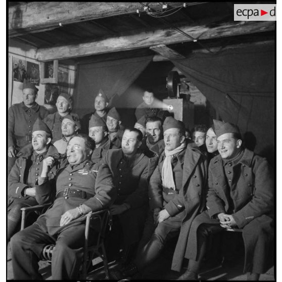 Photographie de groupe de soldats de différentes unités de la 2e armée qui assistent à une séance de cinéma aux armées.