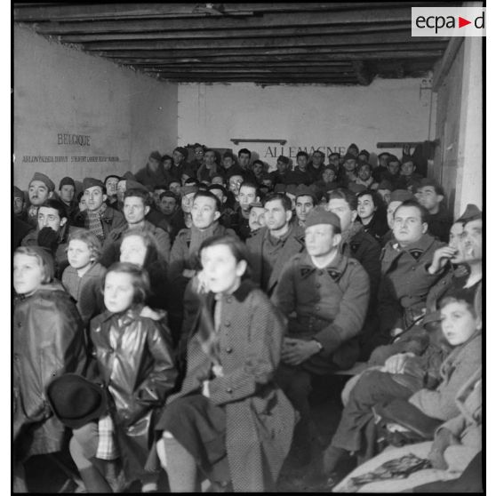 Photographie de groupe de soldats de la 2e armée qui assistent à une séance de cinéma aux armées.