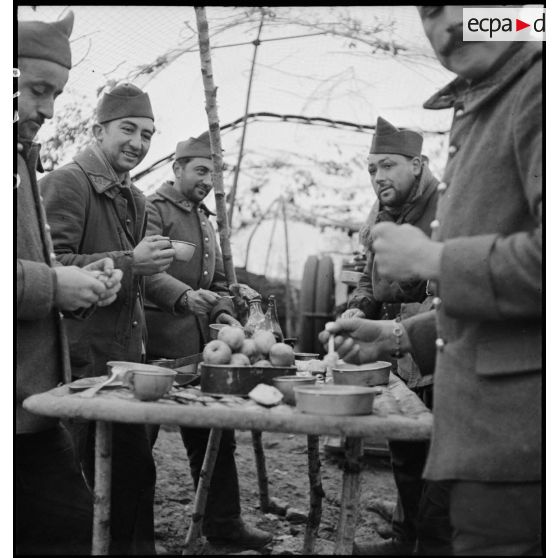 Photographie de groupe d'artilleurs du 185e RA qui mangent dehors.