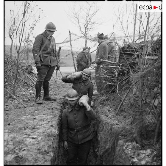 Photographie de groupe d'artilleurs du 185e RA qui portent des obus.