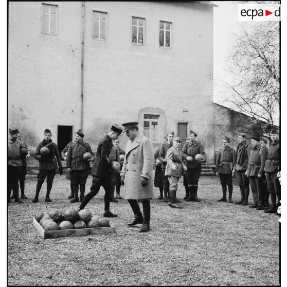 Le général d'armée Edouard Réquin, commandant la 4e armée, et un officier supérieur du corps expéditionnaire britannique (ou BEF- British expedionary force), distribuent des ballons de football à des soldats d'unités de la 4e armée.