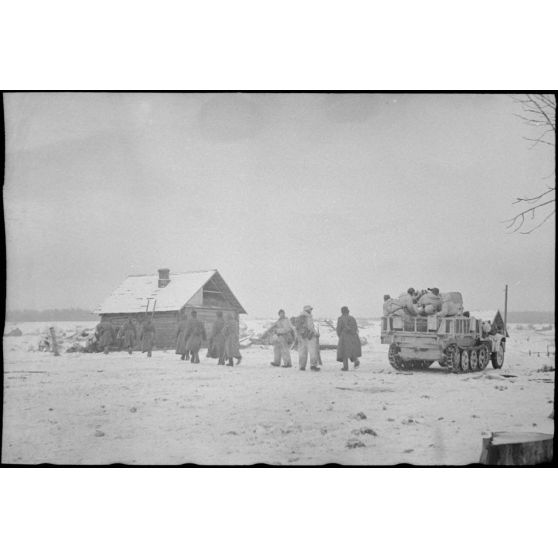 Sous la protection du canon de 2 cm Flak 38 installé sur un semi-chenillé Sd.kfz.10/4, des prisonniers soviétiques sont mis à l'abri d'une isba.