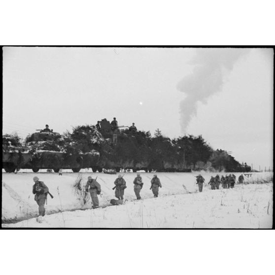 Le retour d'une patrouille de Jäger allemands vers un train blindé, les tubes quadruples du 2 cm Flakvierling dominent les structures du train allemand.