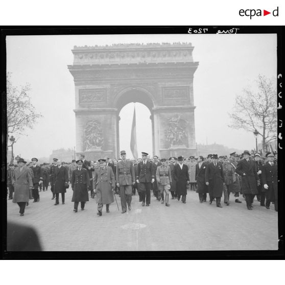 Défilé du général de Gaulle et de Winston Churchill, suivis du cortège officiel, sur les Champs-Elysées lors de la cérémonie du 11 Novembre 1944 à Paris.