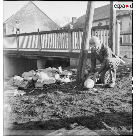 Sapeur du 87e ou 96e Bataillon du génie désamorçant une bombe laissée par l'armée allemande près d'un pont sur le Rupt ou la Lizaine.