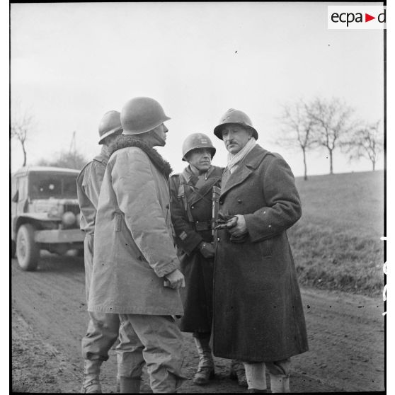 Le général Carpentier, commandant la 2e DIM, entouré d'officiers de son état-major, s'entretient avec le colonel Schlesser à la tête du CC4 dans le secteur d'Héricourt occupé par la division.