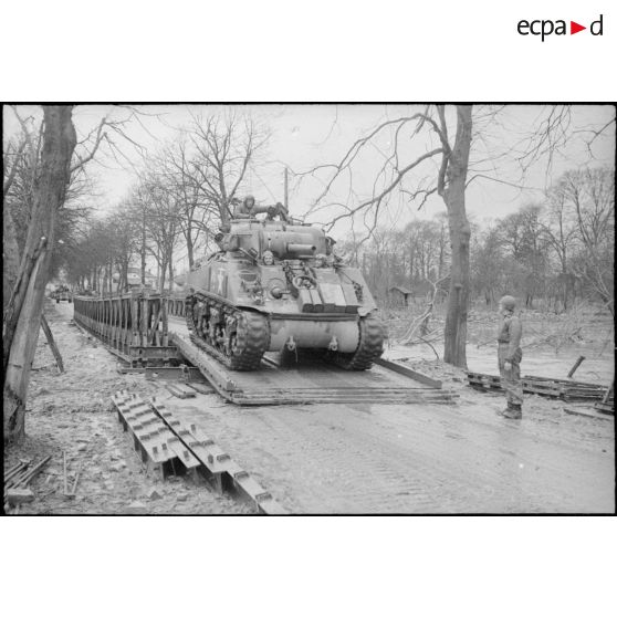 Une colonne de chars Sherman M4 d'une division blindée américaine franchit un pont Bailey lors de sa progression vers Strasbourg.