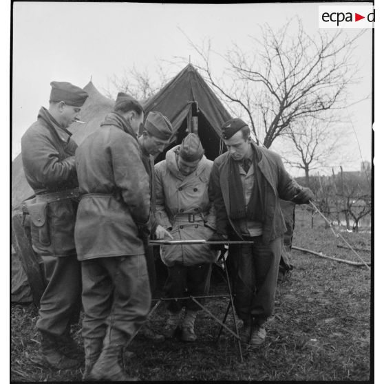 Briefing d'équipages de piper cubs de reconnaissance, de la 25e section d'observation d'aviation d'artillerie (25e SOAA) de la 2e division blindée (2e DB), avant un départ en mission.