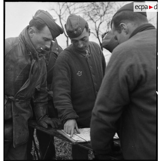 Briefing d'équipages de piper cubs de reconnaissance, de la 25e section d'observation d'aviation d'artillerie (25e SOAA) de la 2e division blindée (2e DB), avant un départ en mission.