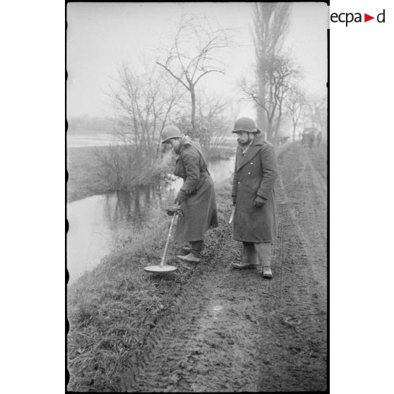 Entre Benfeld et Wintternheim, des sapeurs de la 3e compagnie du 13e bataillon du génie déminent les abords d'un sentier à l'aide d'un détecteur de mines.