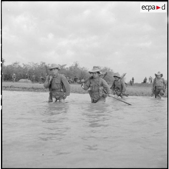 Progression d'éléments du bataillon de marche indochinois (BMI) à travers les rachs, de l'eau jusqu'à la taille, au cours de l'opération Marécages au nord d'Haïduong.