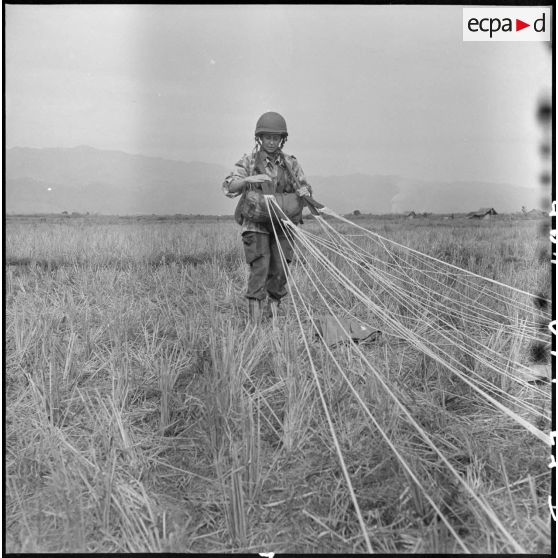 Brigitte Friang, reporter de guerre et rédactrice à la revue Indochine Sud-Est Asiatique, replie son parachute après un saut au cours de l'opération Castor.