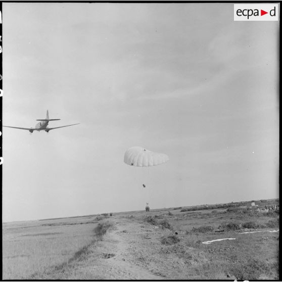 Parachutage de vivres par avion Douglas C-47 Skytrain (Dakota) au milieu des rizières lors de l'opération Brochet.