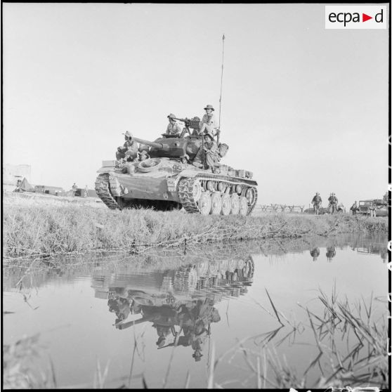 Progression d'un char M24 Chafee du RICM (régiment d'infanterie coloniale du Maroc) équipé d'une mitrailleuse Browning sur un chemin le long d'une rizière lors de l'opération Brochet.