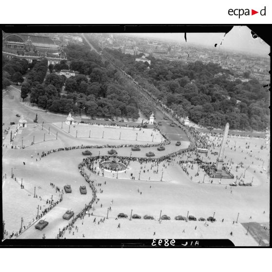 Vue aérienne des cérémonies du 14 juillet 1946 à Paris. Remontant les Champs-Elysées, des chars Sherman traversent la place de la Concorde.