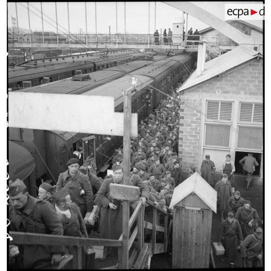 Plan d'ensemble, en plongée d'un quai de la gare de Massy où des permissionnaires descendent d'un train.