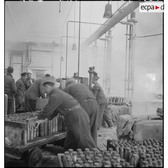 Plan général d'un atelier de l'usine de munitions où des ouvriers travaillent à la confection d'obus.