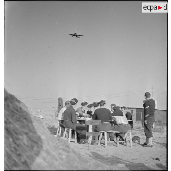 Des marins prennent un repas à proximité de leurs baraquements.