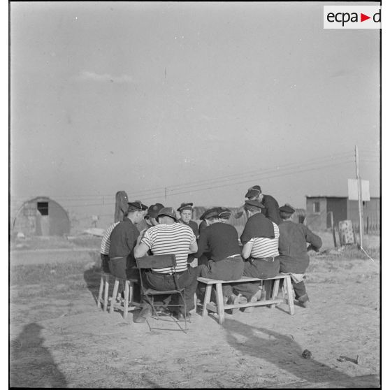 Des marins prennent un repas à proximité de leurs baraquements.