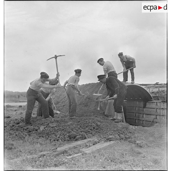 Un officier marinier et des marins effectuent des travaux de terrassement.