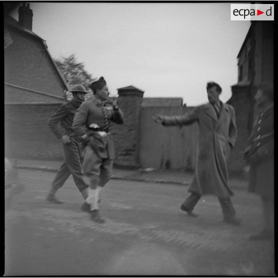 Photographie de groupe de soldats britanniques et français dans une rue.