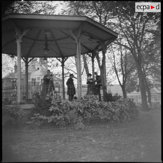 Plan d'ensemble de cameramen qui se tiennent sous un kiosque à musique.