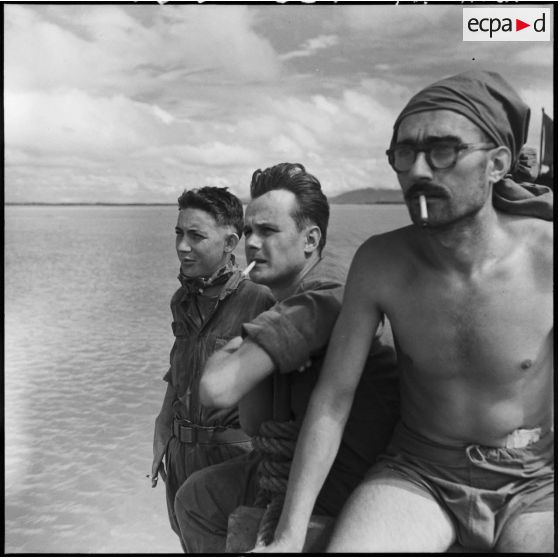 Venant d'être libérés d'un camp Viêt-minh, le cameraman du SPI (service presse information) Pierre Schoendoerffer (au centre) et des camarades sont acheminés vers Hanoï à bord d'un LCM (landing craft materiel).