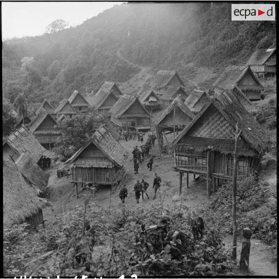 Des soldats de la colonne Godard traversent le village de Phu Teng lors de l'opération Condor.