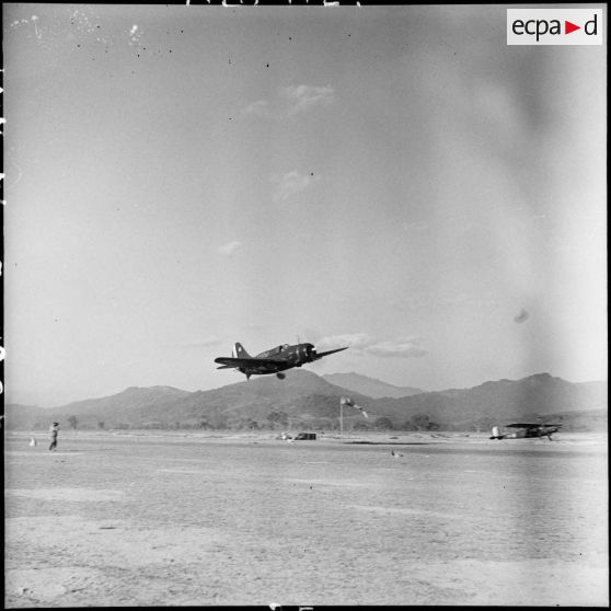 Un avion bombardier SB2C Helldiver de la 3e flottille d'assaut de l'aéronavale survole le terrain d'aviation du camp de Diên Biên Phu.