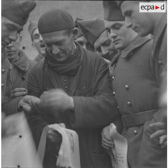 [Abbé vendant des journaux à des soldats, ferme Moncillon, Moselle. 26 octobre 1939.]