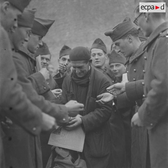 [Abbé vendant des journaux à des soldats, ferme Moncillon, Moselle. 26 octobre 1939.]